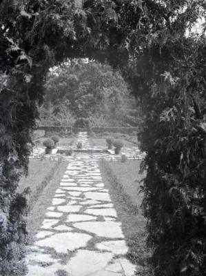 Stone path through arch leading to Morton residence garden