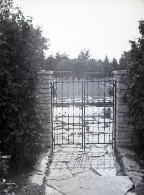 View of Morton residence garden through closed iron gate
