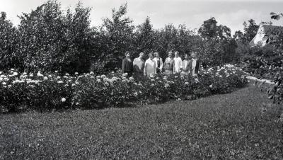 Margaret Gray Morton and friends with peonies and building in right corner