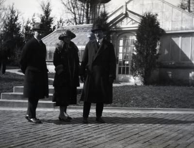 Two men and one woman in front of Morton residence greenhouse