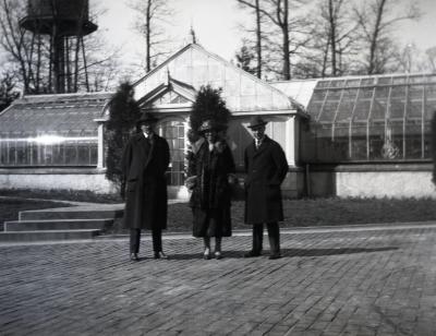  Two men and one woman at Morton residence greenhouse with water tank in background