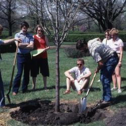 Tom Green with shovel watching tree planting