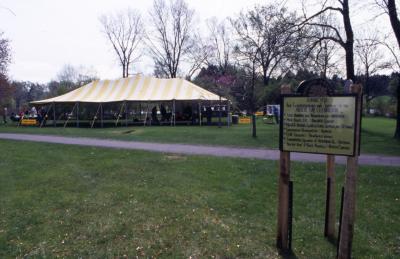 Arbor Week thank you sign at right in field with tent in background