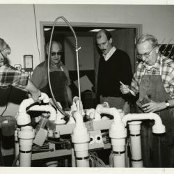 Research crew operating a hydropneumatic elutriation root washing system in laboratory