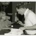 Ed Hedborn examining plant material with woman at Plant Clinic desk