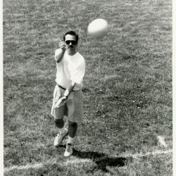 Dr. Gerry Donnelly serving volleyball at employee summer picnic near the Research Building
