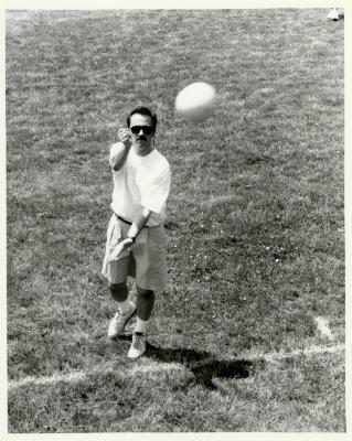 Dr. Gerry Donnelly serving volleyball at employee summer picnic near the Research Building