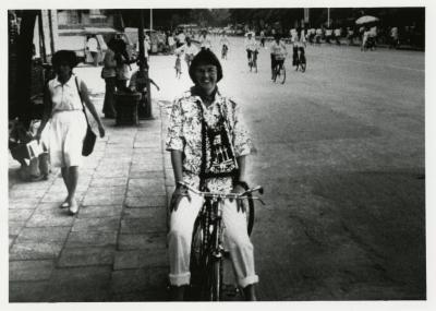 Carol Doty riding bicycle on street in China