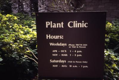 Outdoor Plant Clinic sign post with hours