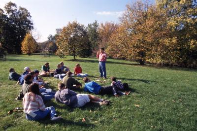 Pat Kelsey talking to Wheaton College soils class outside with students seated on ground