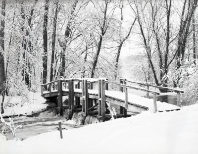 Wooden bridge covered in snow over DuPage River dam