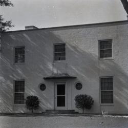 Clarence Godshalk's second Arboretum house, exterior front view with dog in lawn near walkway