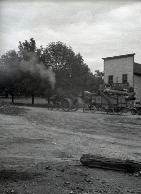 Lisle Farms threshing outfit in front of Riedy's drug store in Lisle, angled view