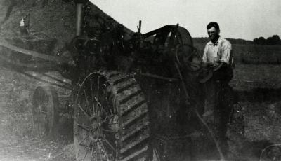 Man operating thresher at Lisle Farms
