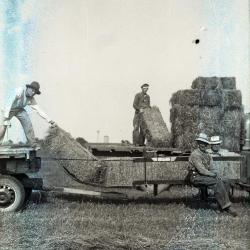 Men with baled hay on trailer at Lisle Farms