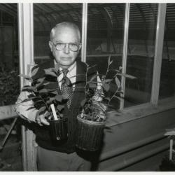 George Ware holding potted greenhouse seedlings from China Collection