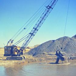 Arbor Lake excavation, man operating equipment in partially filled lake
