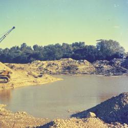 Arbor Lake excavation, man operating equipment to the left of partially filled lake