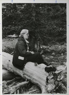 Elizabeth "Sody" Zimmerman seated on fallen tree trunk