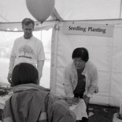 Arbor Day activities at The Morton Arboretum, child at Seedling Planting station talking to Tom Simpson and Heidi Tamanaha