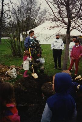 Arbor Day, child and Carolyn Finzer dressed as Morton Oak planting tree, Scott Mehaffey speaking on microphone to crowd