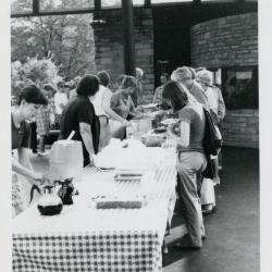 Fish Boil: Susan Klatt and others serving food and beverages behind tables outside Visitor Center