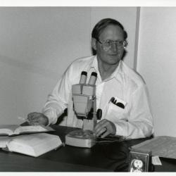 Ross Clark working with microscope at desk