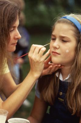 Woman painting girl's face on Arbor Day