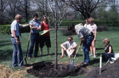 Tom Green with shovel watching tree planting