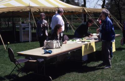 Staff at ticket and information table in front of tent during Arborfest