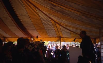 Charles Haffner at podium speaking to crowd in tent on Earth Day