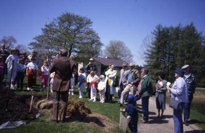 George Ware speaking at Arbor Day tree planting  (facing crowd) with Visitor Center in background