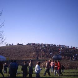 Crowd walking up berm and lined up on top of berm on Earth Day