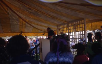 Dr. Marion Hall speaking to crowd in tent on Earth Day