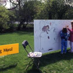 Two young girls coloring on Coloring Mural during Arbor Week