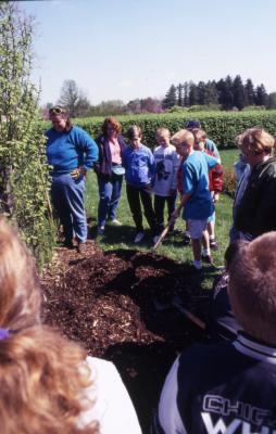 Group with Deb Seymour near Hedge Garden shoveling soil at Arbor Day tree planting