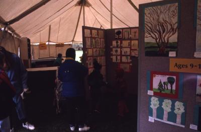 Visitors viewing children's artwork in Arbor Day children's tent