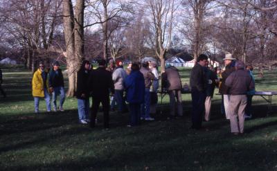 Employees gathered near refreshments table at Arbor Day employee tree planting