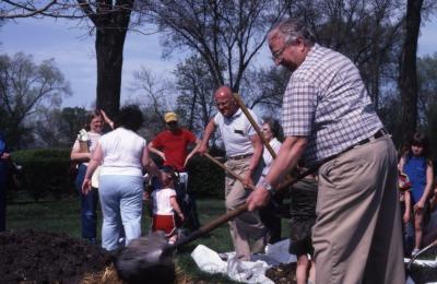 Dick Wason planting tree with visitors at Arborfest