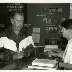 Chris Martner reviewing plant material with man at Plant Clinic desk