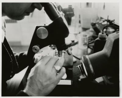 Closeup of man using microscope in laboratory