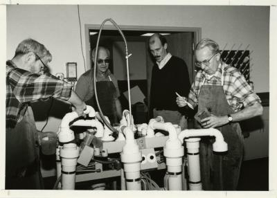 Research crew operating a hydropneumatic elutriation root washing system in laboratory