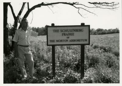 Ray Schulenberg with prairie sign in the Schulenberg Prairie