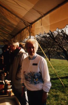 Helen Langrill next to refreshment table in tent during Earth Day celebration and berm planting