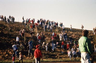 Crowd ascending berm for Earth Day celebration and berm planting