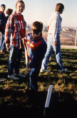 Woman supervising young boy with shovel during Earth Day celebration and berm planting