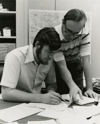 Floyd Swink and Gerry Wilhelm reviewing documents at desk
