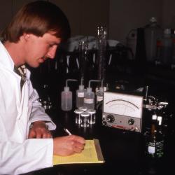 Rick Hootman in lab coat taking notes from chloride analysis of soil extract in lab
