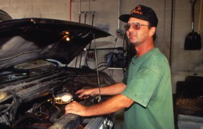 Mike Abel working in garage with truck hood open