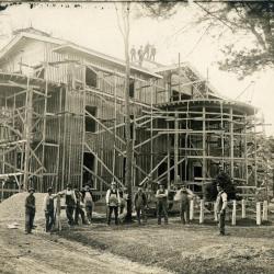 Arbor Lodge remodeling construction, house with rotundas framing erected, workmen in front